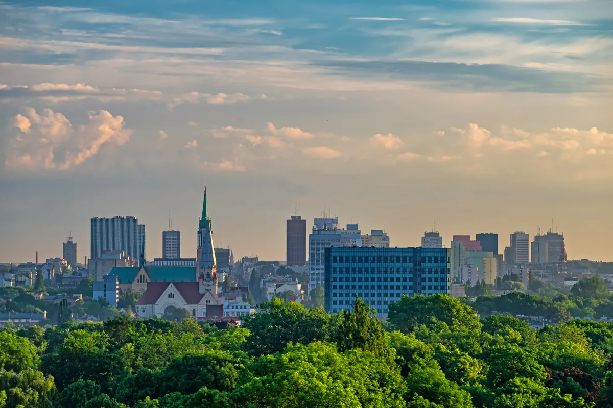 Panorama Łodzi o złotej godzinie z wieżą kościoła i zabudową śródmieścia