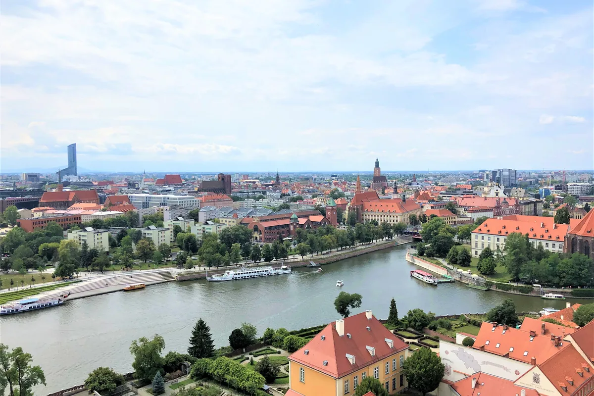 Panorama Wrocławia znad Odry z czerwonymi dachami starówki